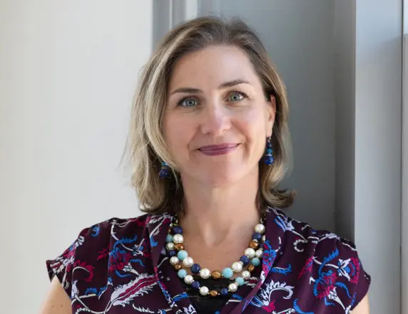 A woman with short hair wearing a necklace.