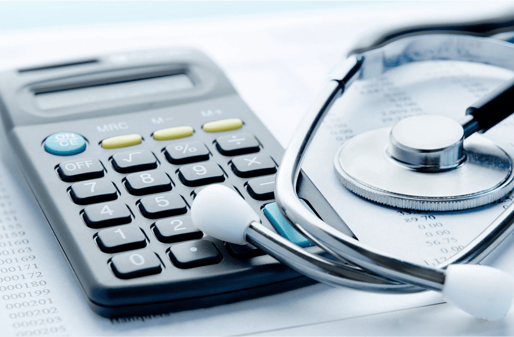 A calculator and stethoscope on top of a table.